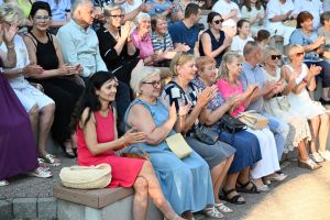 Zdjęcie: kobiety i mężczyźni siedzący na widowni w amfiteatrze